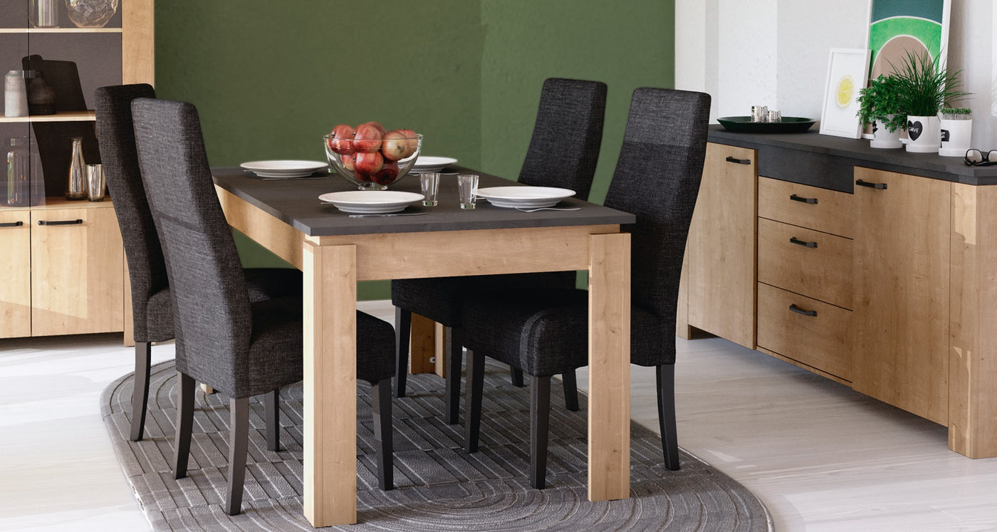 Eetkamer met een moderne houten eettafel en zwarte stoelen, licht houten kast en dressoir, met groene muuraccenten en decoratieve elementen.