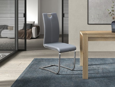 Moderne grijze stoel met hoge rugleuning en uniek verchroomd slede-onderstel, geplaatst in een eigentijdse woonkamer setting.