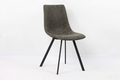 Stijlvolle moderne stoel met een grijze suède zitting en contrasterende zwarte metalen poten, perfect voor een eigentijdse eetkamer of kantoor.