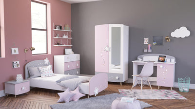 Stijlvolle kinderkamer ingericht met roze en witte meubels, waaronder een bed, kast, ladekast en bureau met opbergruimte. De kamer heeft decoratieve sterren en wolken, en biedt een speelse en georganiseerde omgeving voor kinderen.